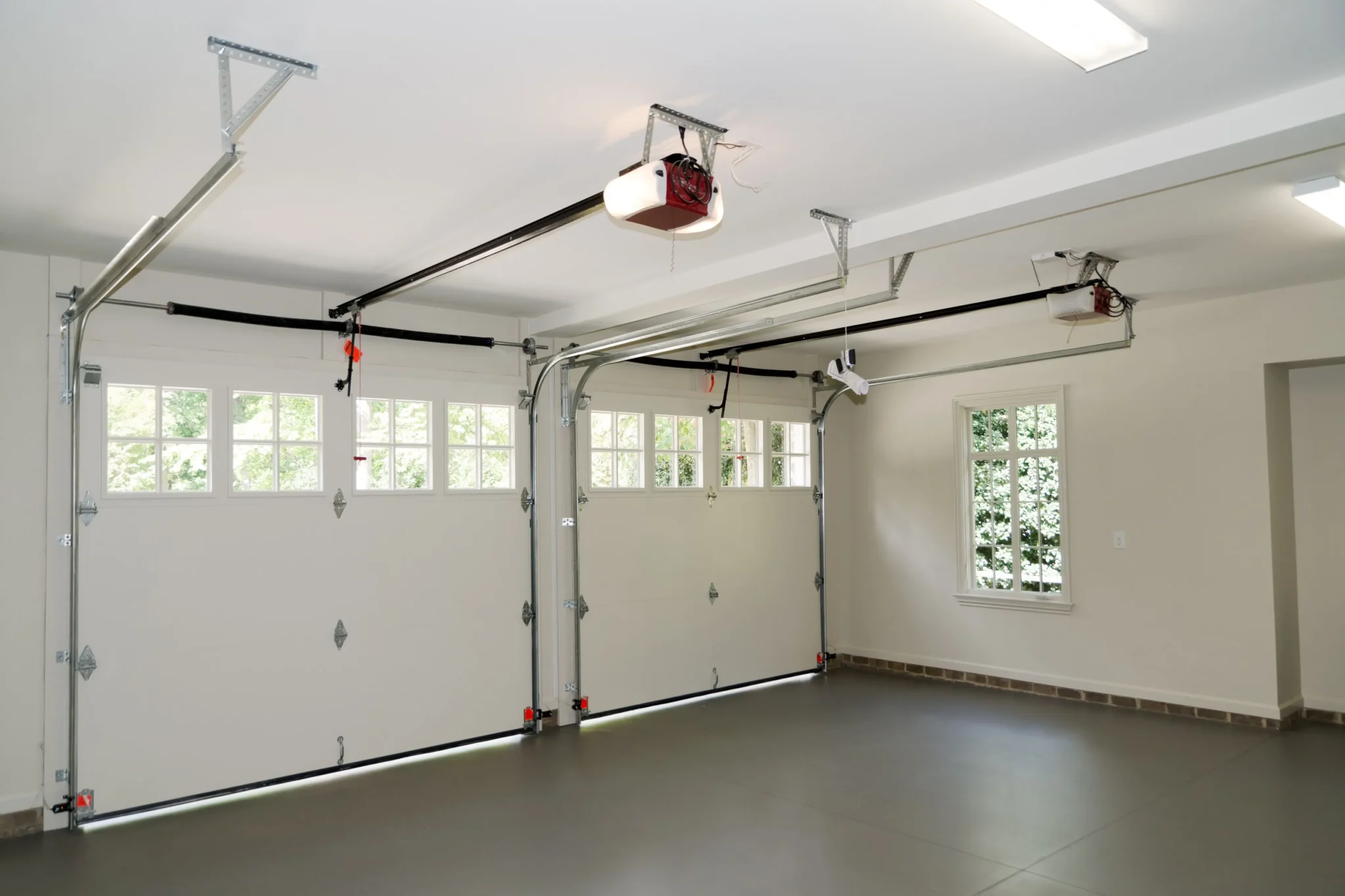Inside a garage — the door tracks, rollers, cables and opener