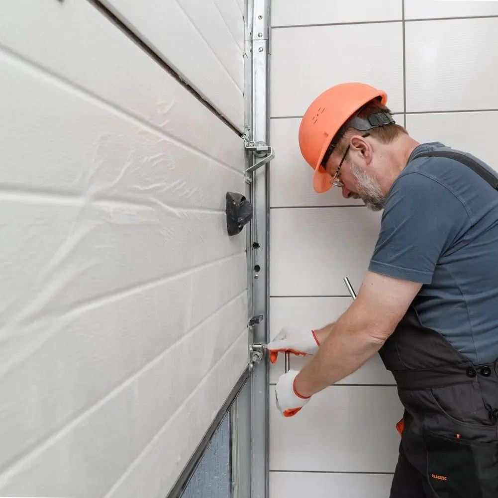 A technician repairing a garage door panel and side track