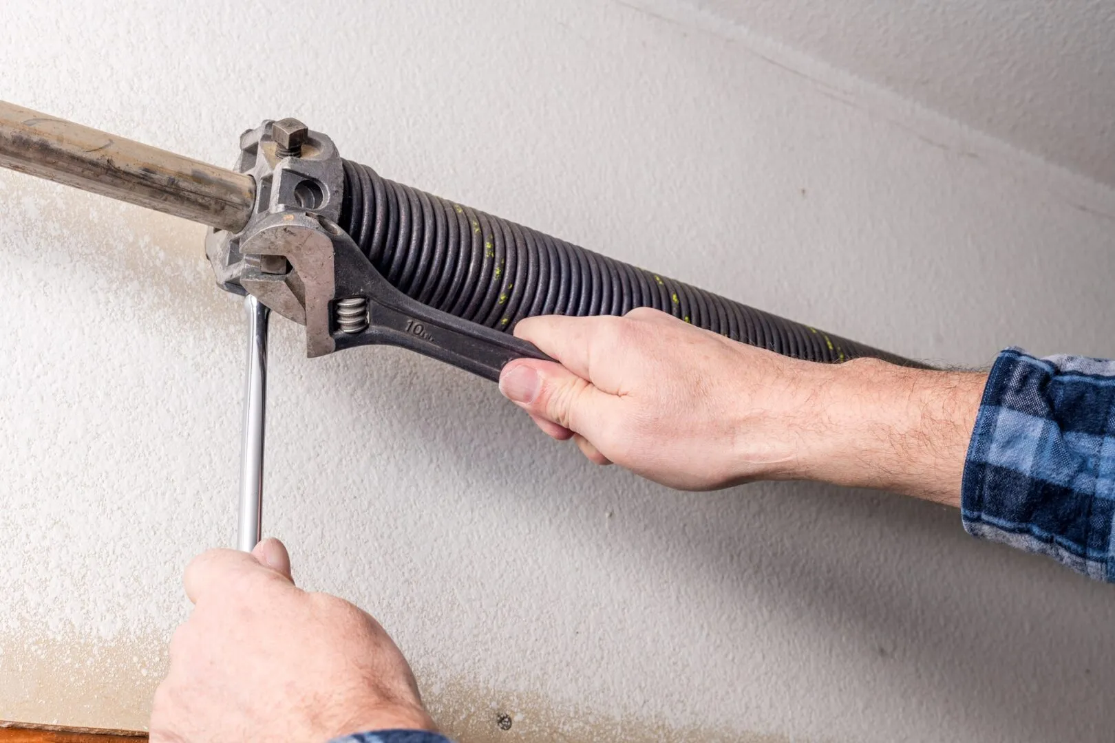 Close-up of a garage door torsion spring on the shaft above the door